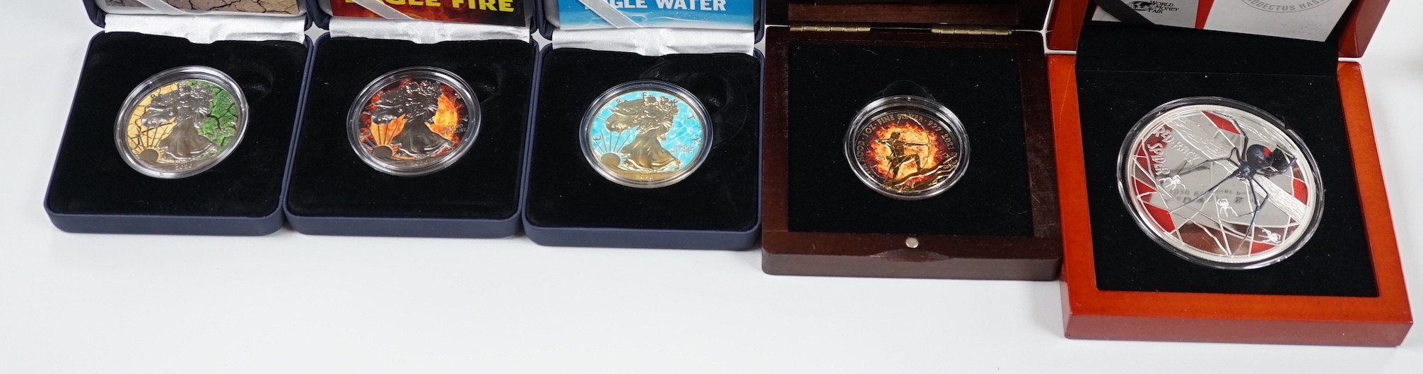 A World Money Fair Red back spider 5oz. Proof silver coin, three art colour 1oz. Silver dollars and a Burning Robin Hood 1oz. BU silver coin (5)